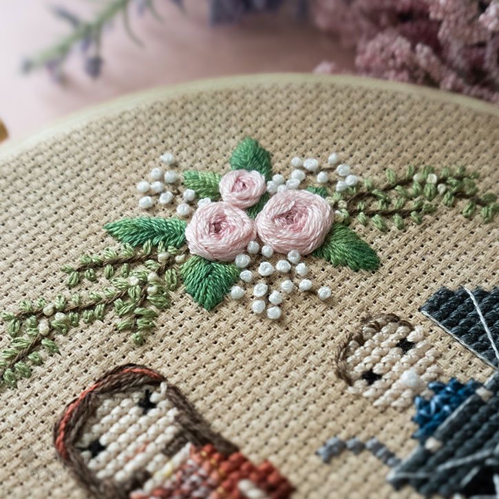 A close-up of the stitched portrait's florals