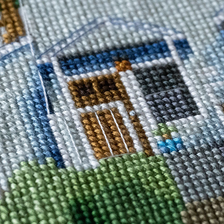 A close-up photo of the details of a cross-stitched house piece