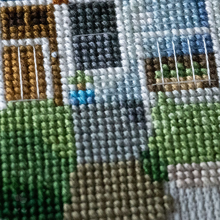 A close-up photo of the details of a cross-stitched house piece