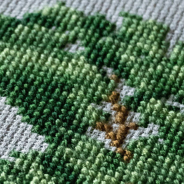 A close-up photo of the details of a cross-stitched house piece