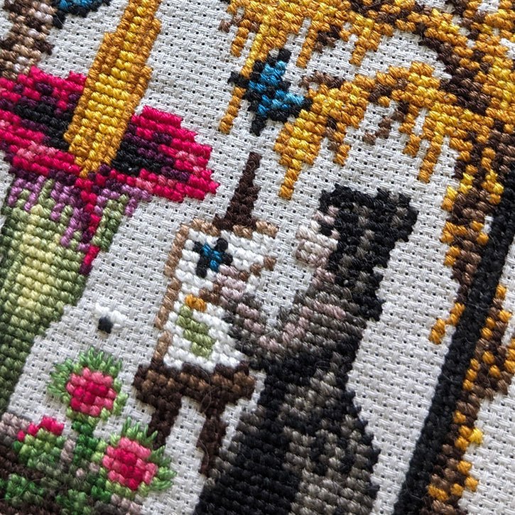 A close-up photograph of a section of the "Greenhouse of Oddities" cross-stitch piece.