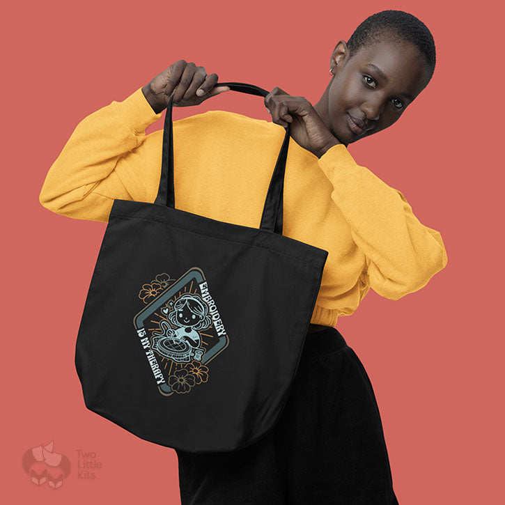 A mock-up photograph of a short-haired woman holding a black tote bag which has the "My Therapy" design on it