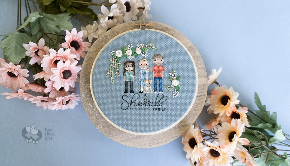 A cross-stitched portrait of a family of three people and one dog, known as "the Sherrills". Above and around the characters is hand embroidered flowers.
