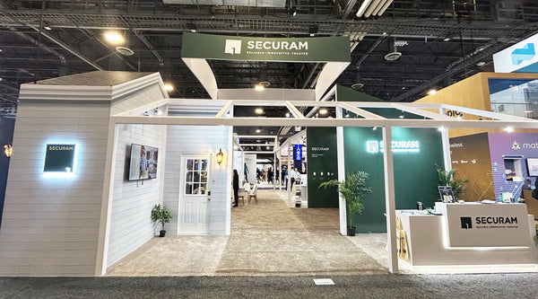 "An exhibit booth for SECURAM at a trade show with a modern, house-like design.