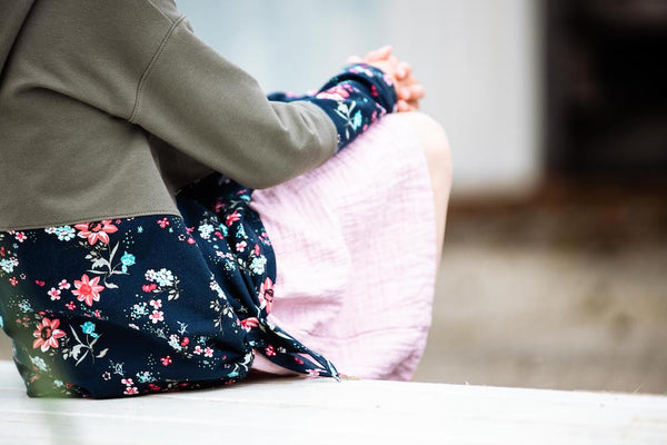 Mädchen in Keidung aus Fairtrade Biostoffen von Faybee mit Blumen und Oliv