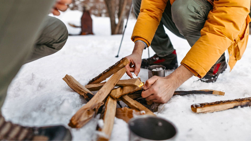 Essential winter camping gear. Camper building an emergency fire. I Go Overland Blog.