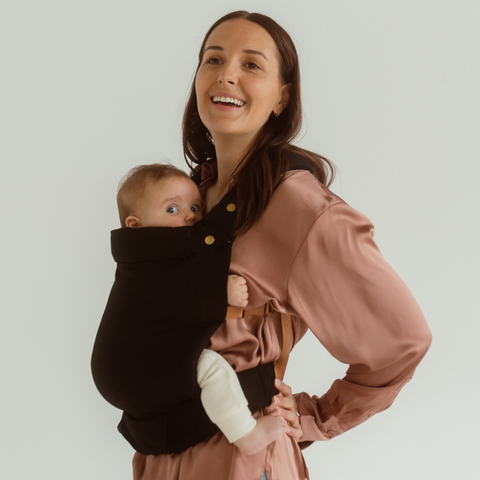 Kasey wears the Jett Clip Carrier by Chekoh baby with her settled baby