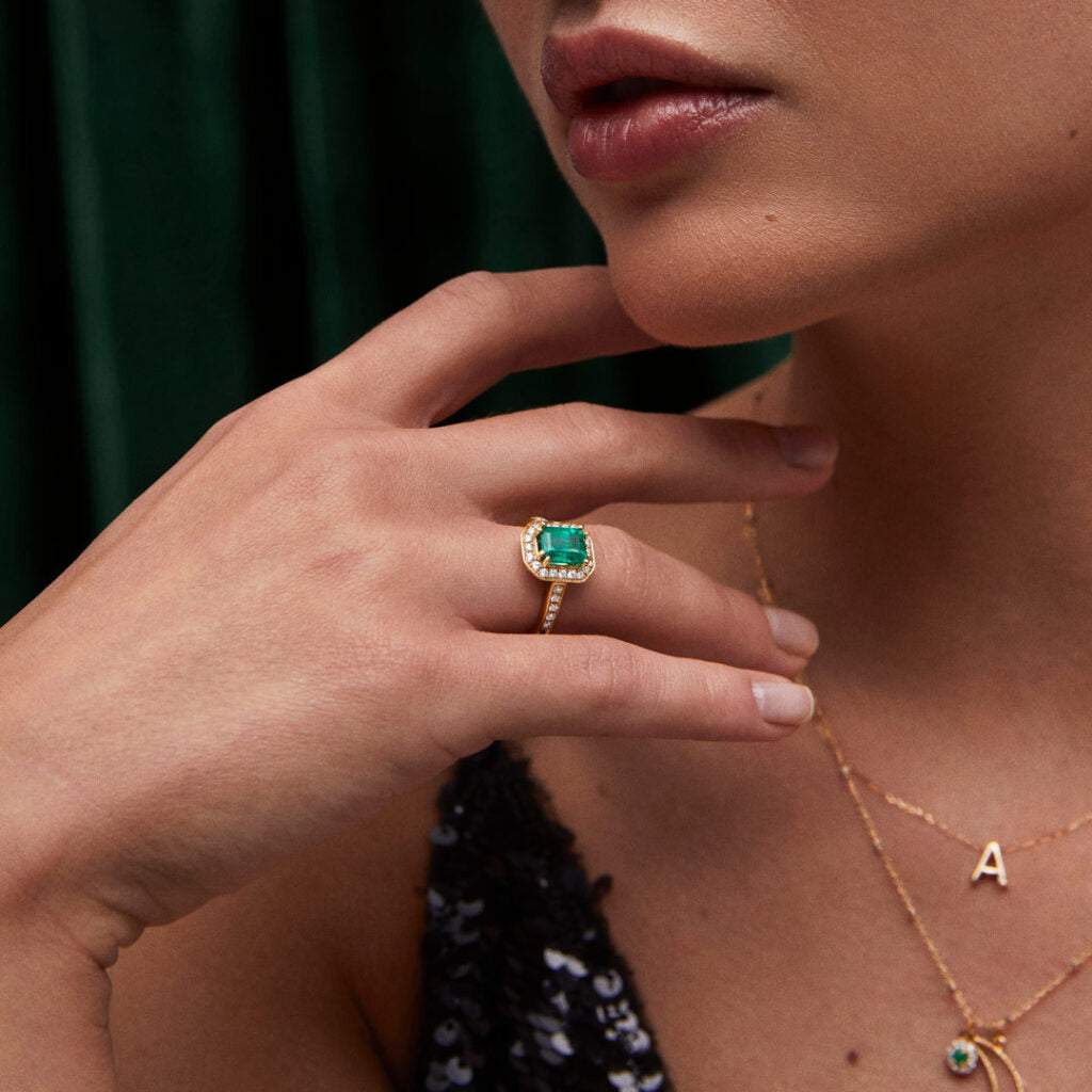 Model with windsor ring with emerald and diamonds in yellow gold