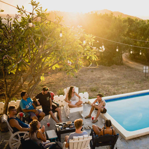 Family and friends happily gather around the pool in the backyard