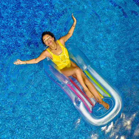A hot girl enjoying herself in the middle of the pool with her arms outstretched.