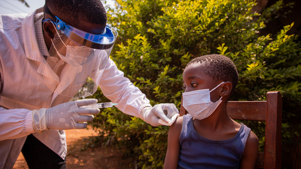 Doctor giving a small boy a needle