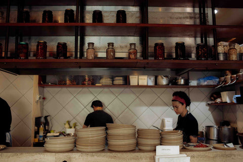 Ortolana's open kitchen with Lil Ceramics plates stacked on the counter