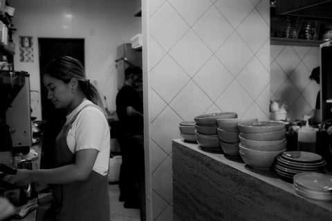 Black and white image of Ortolana Barista and kitchen team, with stack of Lil Ceramics bowls on the counter