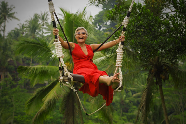 mature woman laughing on swing