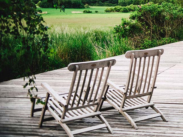 Two empty chairs on a deck by Markus Spiske