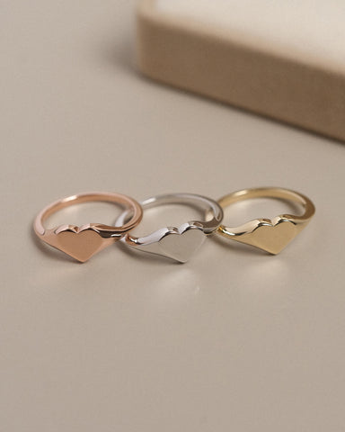 Photo of a yellow, rose and white gold heart shaped signet ring.
