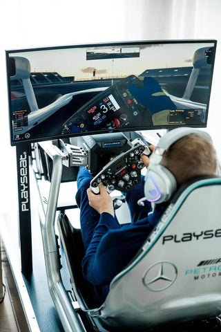 Playseat F1 Pro Mercedes Edition with man sitting in the cockpit playing a racing game