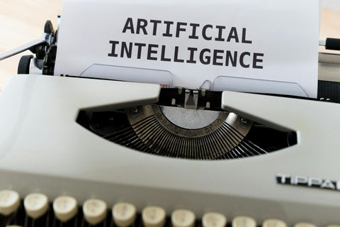 Analog Typewriter typing the words Artificial Intelligence on paper symbolizing the merging of human intelligence and artificial intelligence for hybrid intelligence