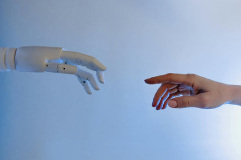 robot hand with index finger pointing to human hand with index finger pointing like "The Creation of Adam" painting