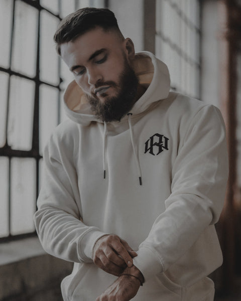 young male model wearing a RENOWNED WEAR Cream logo Hoodie