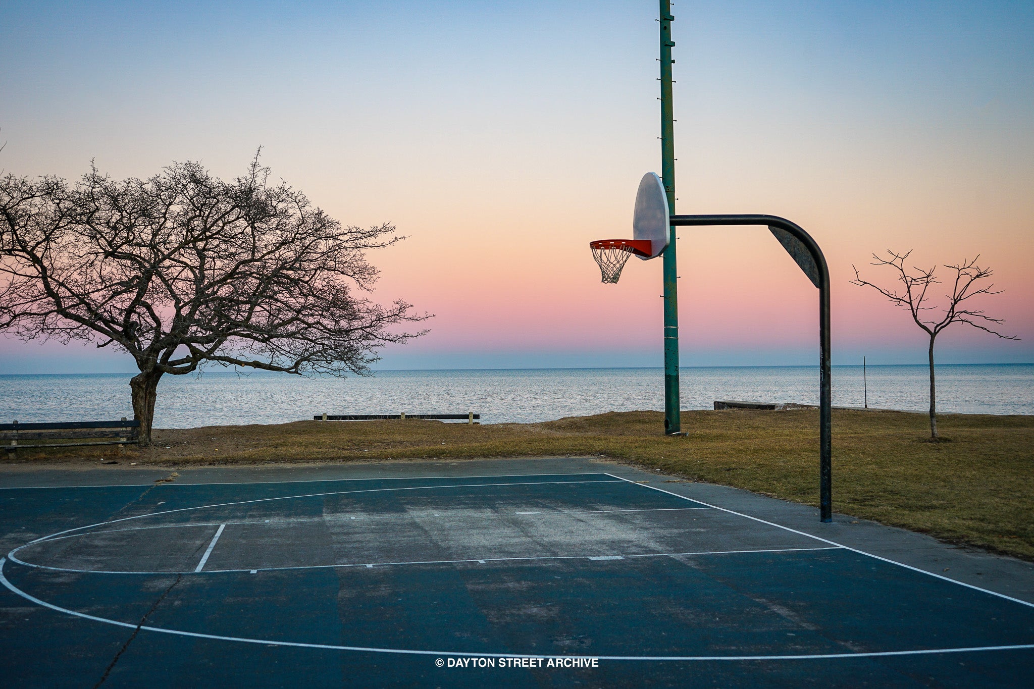basketball hoop with beautiful scenery, lake, sunset rainbow in background