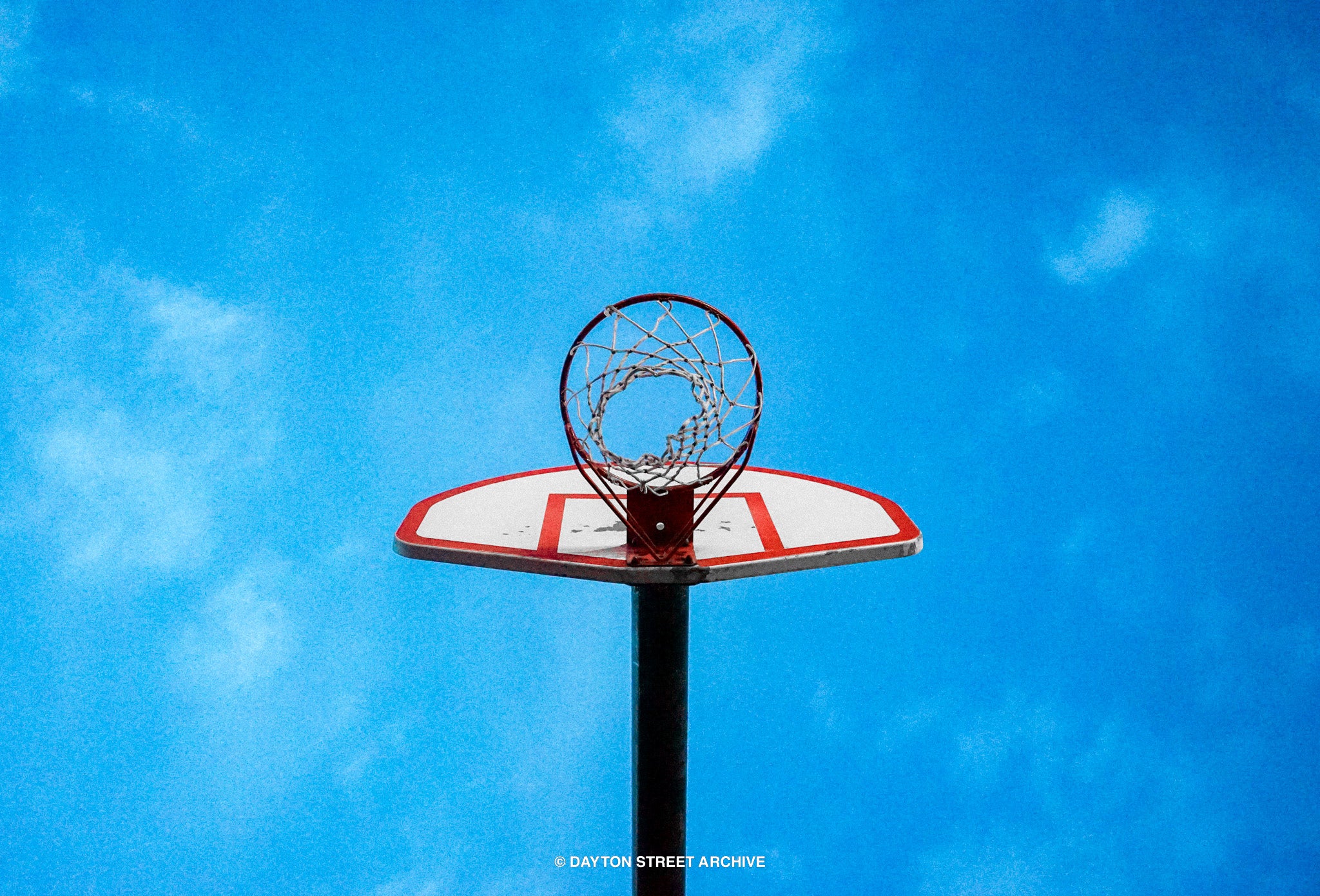 under basketball hoop, beautiful bright blue sky