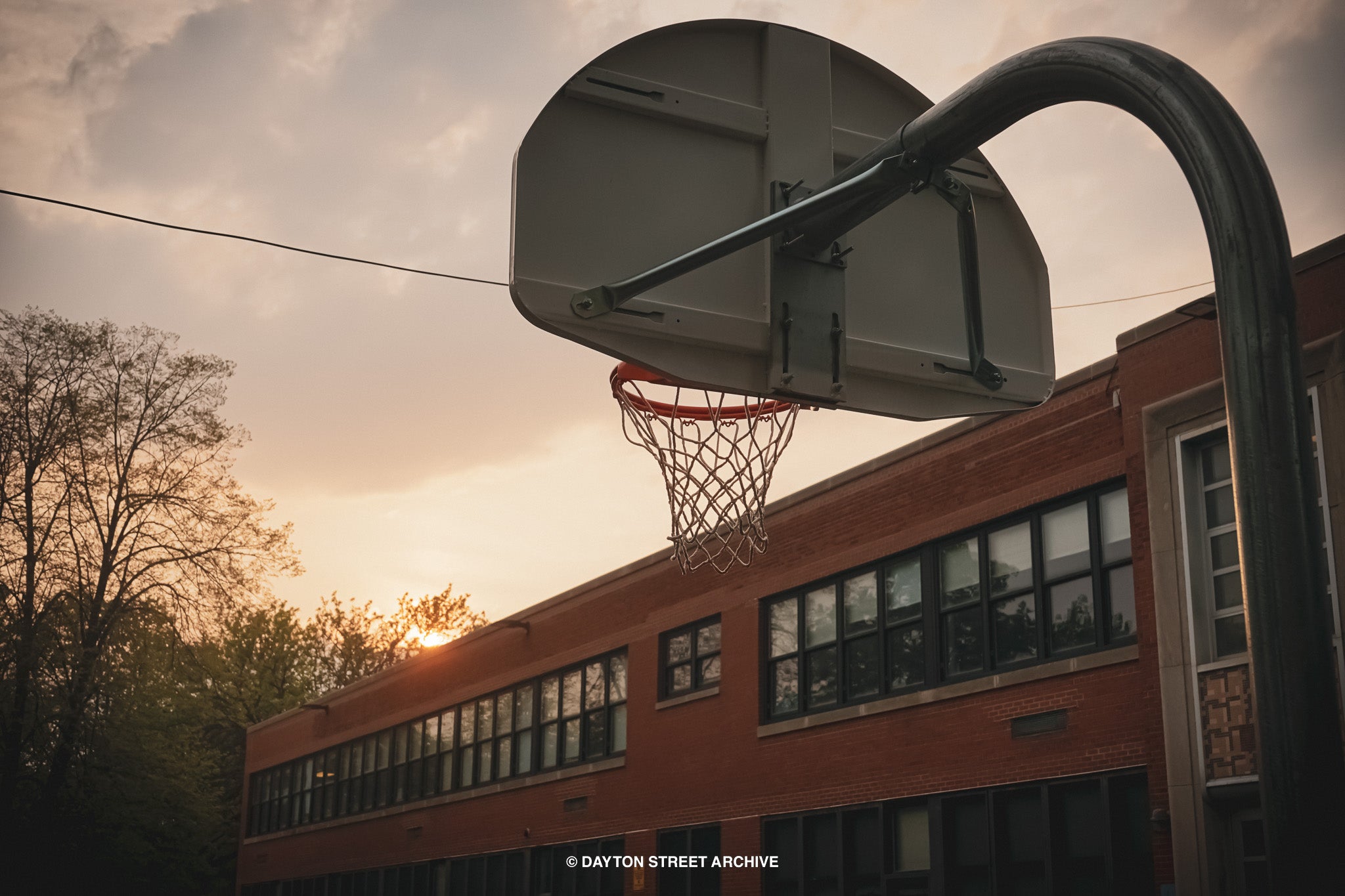 basketball hoop photograph with sunset sky