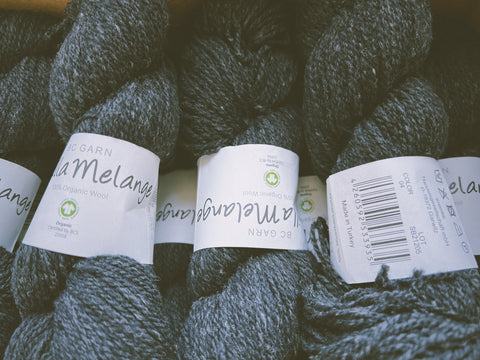 a row of organic yarn skeins in dark grey 