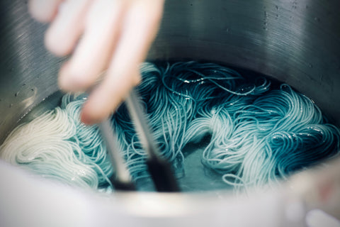 hand dyer's hand dyeing blue yarn