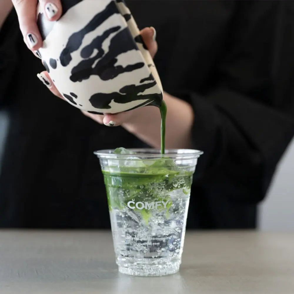 Person serves matcha using a pottery matcha bowl with spout at Kyoto's coffee store Comfy