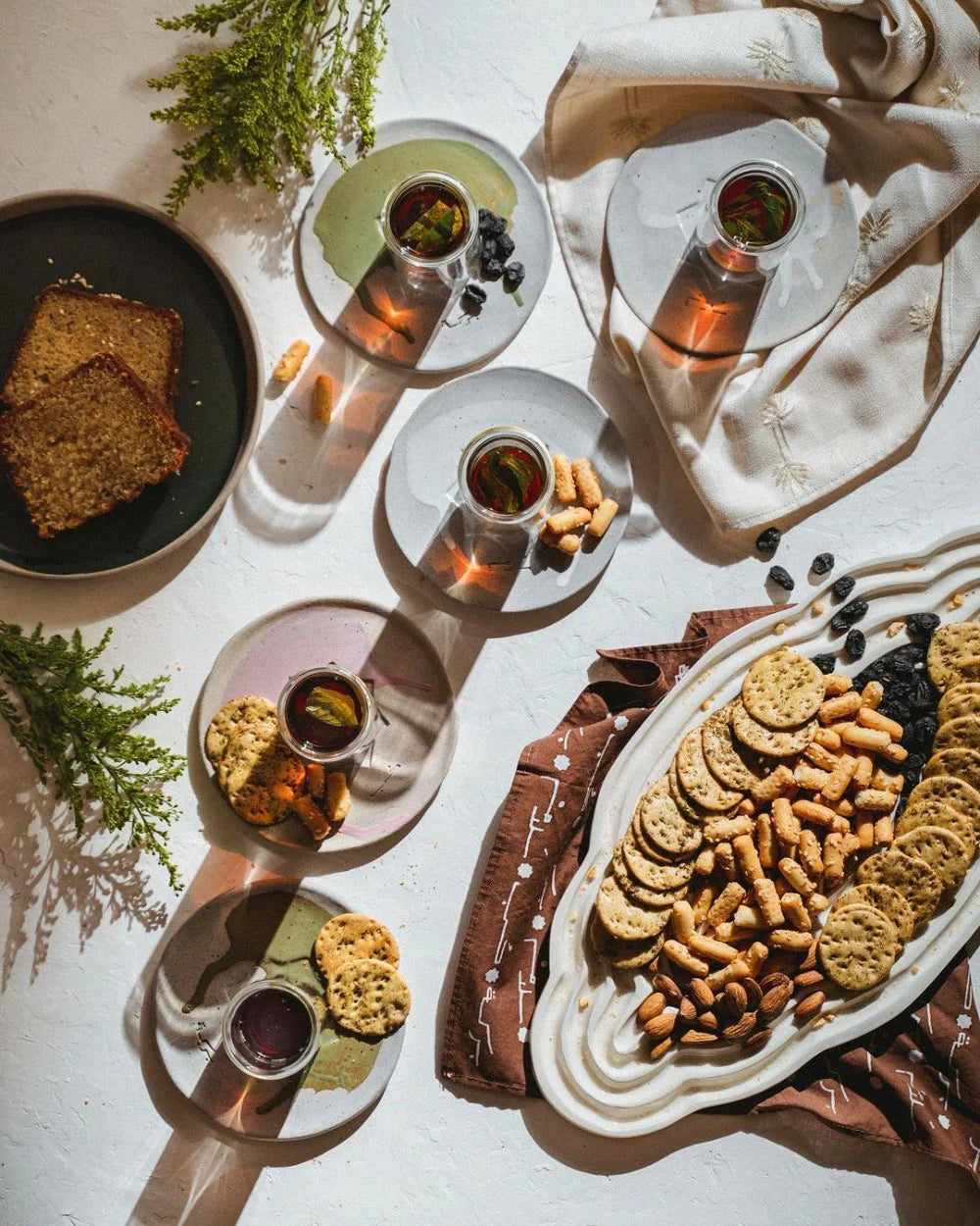 Table setting with tea and appetizers served on a custom ceramic platter by OWO Ceramics