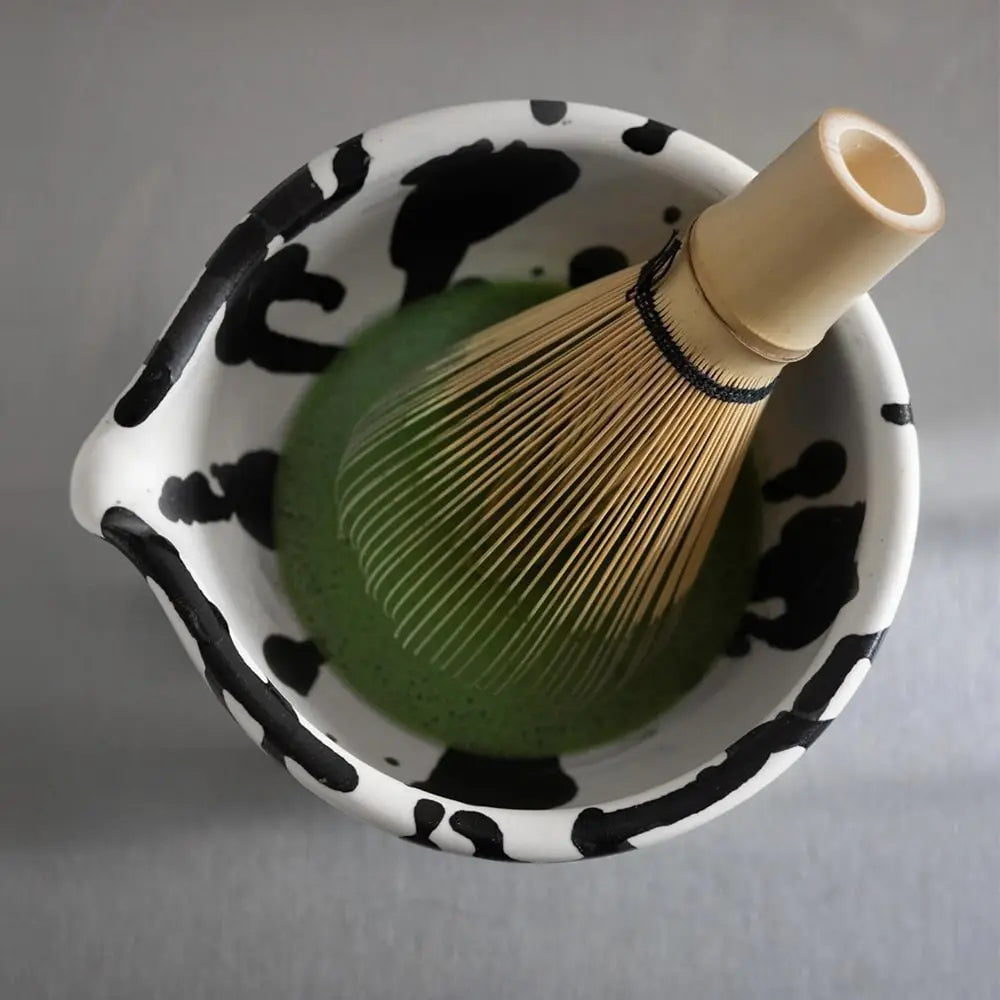 Matcha tea being prepared in a handmade ceramic matcha bowl with spout at Kyoto's coffee shop Comfy