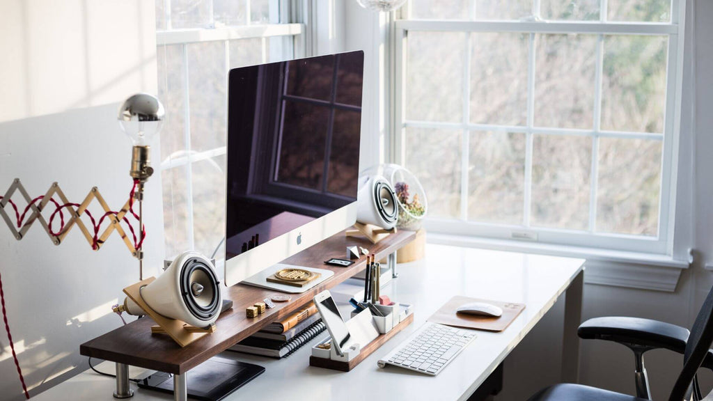 modern desk setup with lamp and storage next to large window