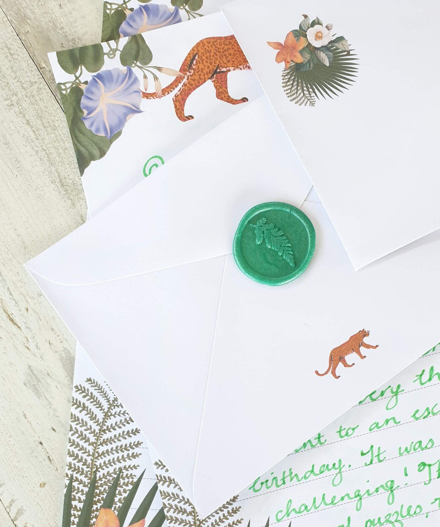 envelope and handwritten letter with floral paper and green wax seal