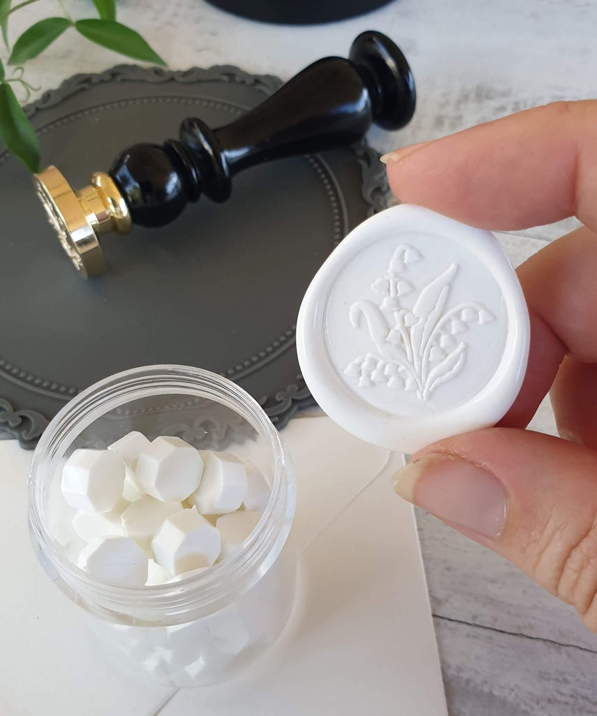 hand holding white lily flower wax seal