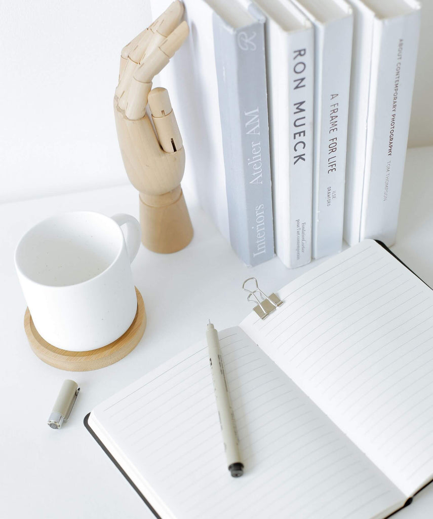 white office desk with notebook and pen