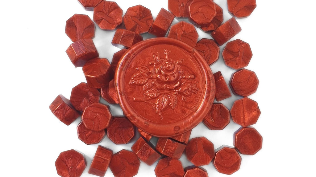 red sealing wax beads and a red wax seal used in traditional wax seals