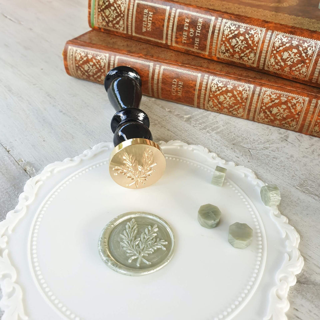 sage green wax seal with with rosemary leaf design
