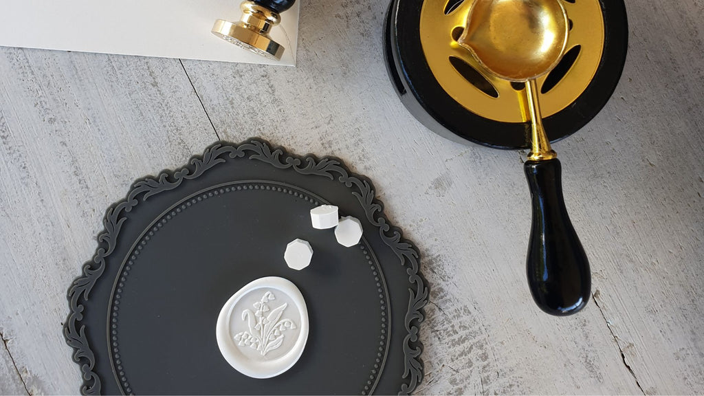 wax melting stove and spoon set with white wax seal on mat