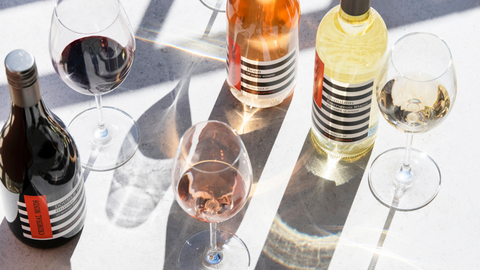 Variety of wines and glasses spread on a table.