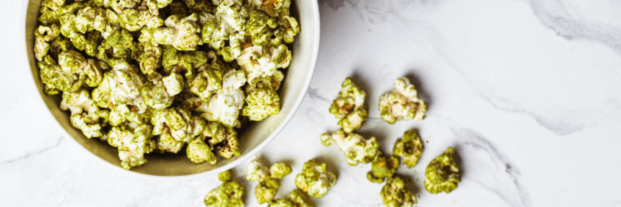 Bowl of popcorn sprinkled with green Spirulina Powder