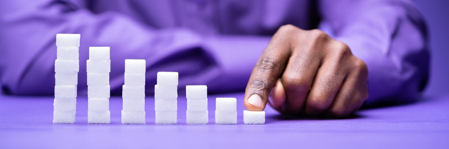 man's hand counting stacked sugar cubes