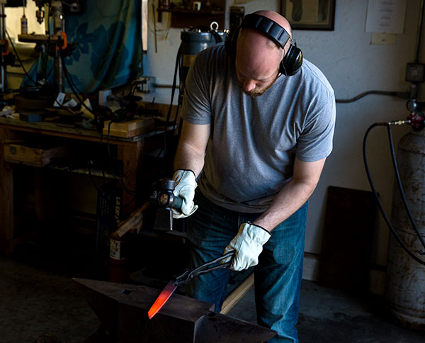 Abe tries his hand at forging in Don Carlos Andrade's shop