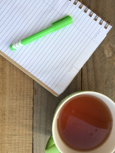 Notebook and cup of tea on a table