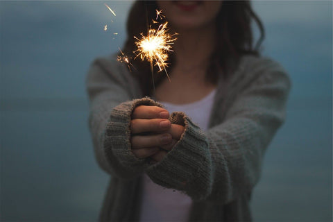 Woman holding a sparkler with both hands