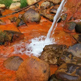 clear stream running over an iron sediment