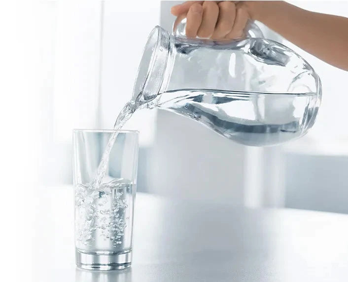 Fresh clean water being poured into a glass from a picture