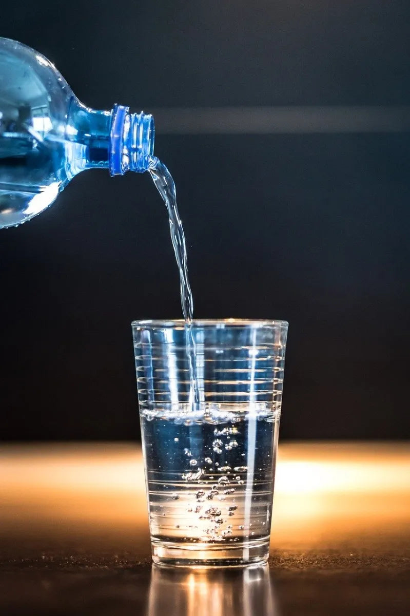 pouring bottled water into a glass