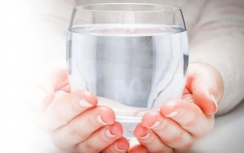 woman holding a glass of purified water