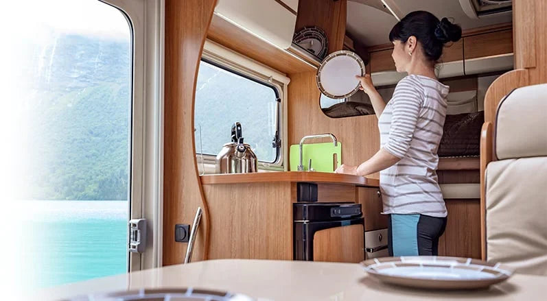 Woman washing dishes in RV with freshly filtered water